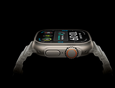 Imagem lateral do Apple Watch Ultra 4 com caixa prateada de titânio e Digital Crown laranja. A tela mostra a hora digital e métricas de saúde e exercícios