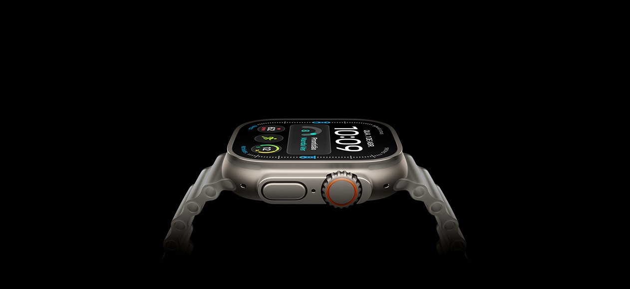 Lateral direita do Apple Watch Ultra 4 com caixa natural de titânio mostrando a Digital Crown, o botão lateral elevado, o mostrador digital e a pulseira Oceano cinza-translúcido