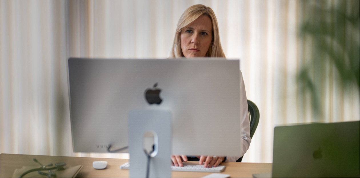 Une prestataire de soins regarde l’écran d’un iMac à son bureau.