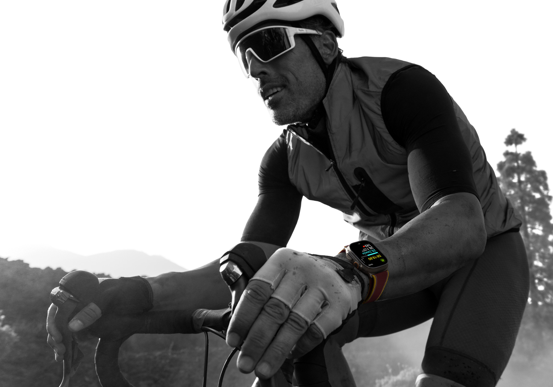Apple Watch Ultra 4-et viselő országúti kerékpáros, a kijelzőjén biciklis mérőszámokkal