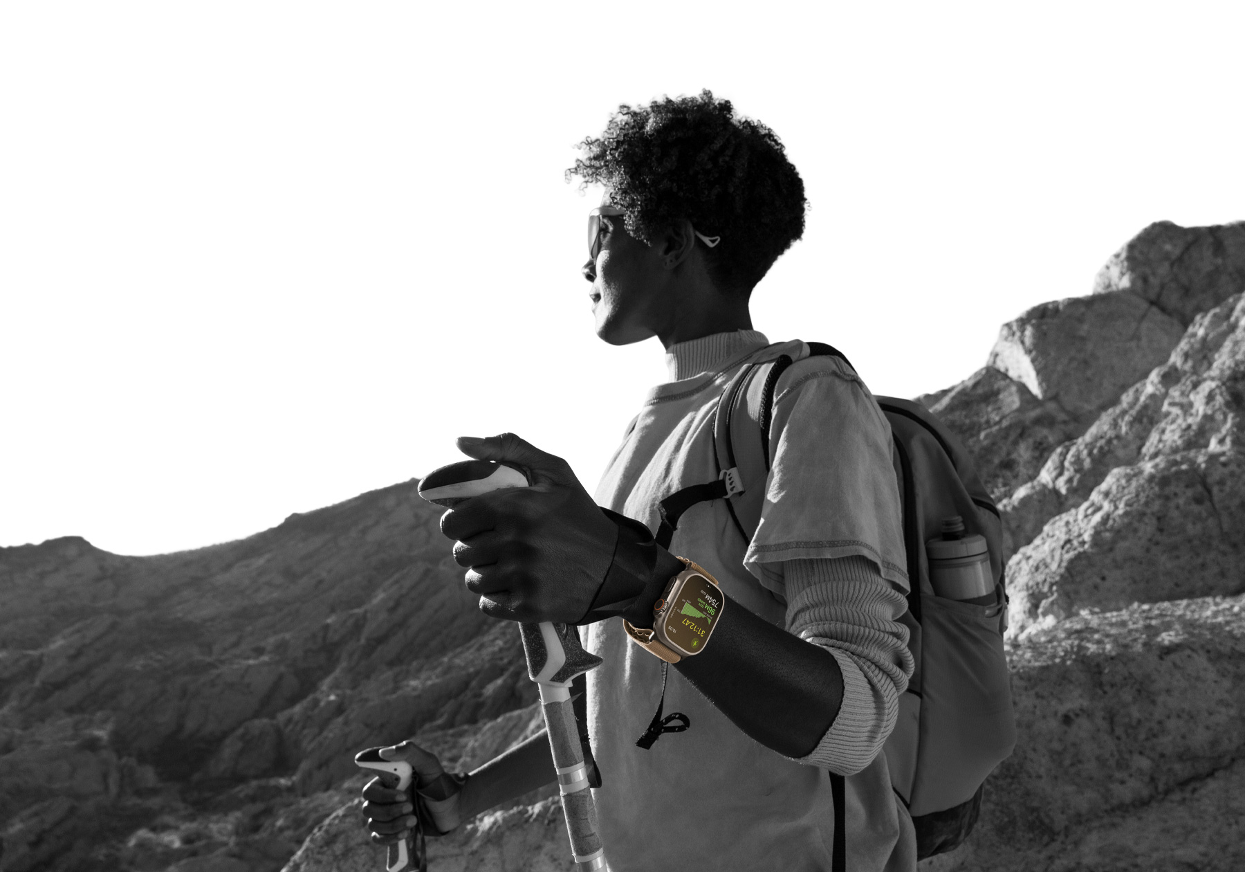 Osoba wędrująca po pustyni z założonym Apple Watch Ultra 4. Na ekranie widać wskaźniki wysokości