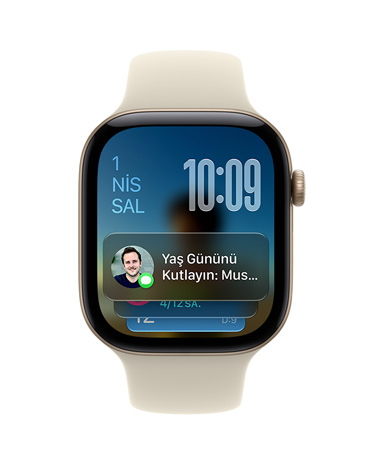 Apple Watch Series 12, Kum Rengi Spor Kordon ve Uçuk Altın Rengi Alüminyum kasa, kadranın sol üst köşesinde tarih, sağ üst köşesinde saat ve altta Mesajlar araç takımı gösteriliyor