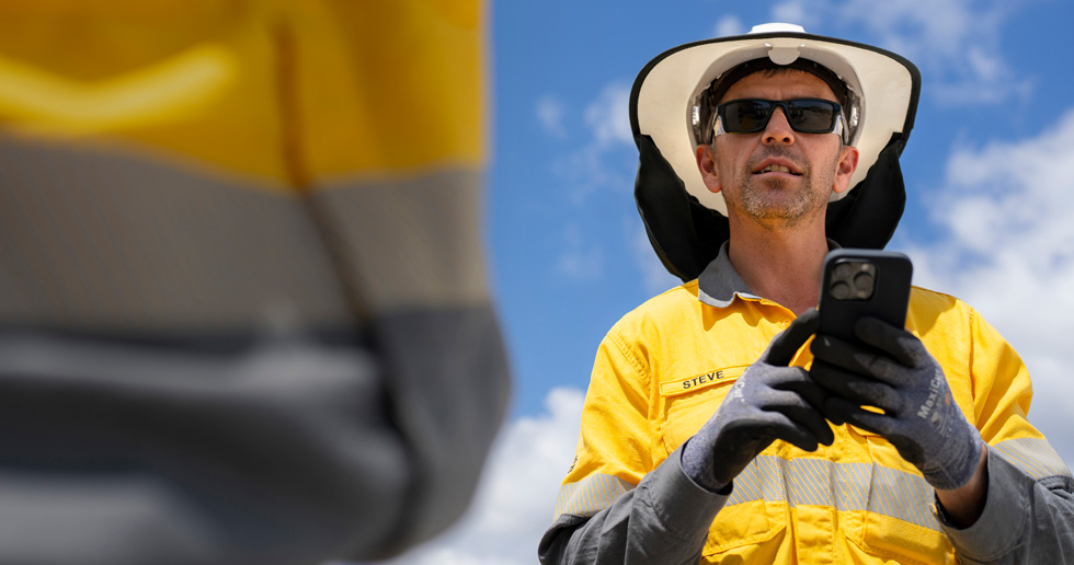 Mitarbeitende im Außendienst nutzen iPhone und iPad, um Baustellen zu bewerten, mit Crewmitgliedern zusammenzuarbeiten und detaillierte Informationen standortübergreifend zu überprüfen